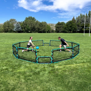 Two people playing gaga ball with Infinets in a field